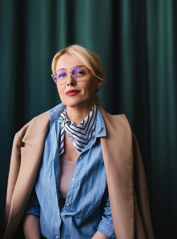 Smiling businesswoman sitting in the cafe and looking at camera.